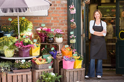 Woman standing in front of her small business flower shop.  10 Step Guide to Starting a Small Business.  The Miller Insurance Agency Everett Washington